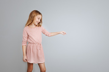 Cute smiling girl standing isolated on grey background