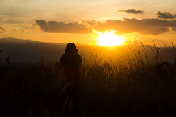 Fototapeta na wymiar standing on a mountain, enjoying the sunset