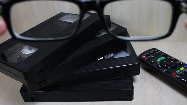 stack of VHS video tape cassette and glass