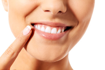 Dental health concept - beautiful woman pointing to her teeth