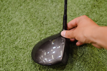 Golf club in hand, green copyspace background