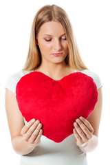 Young woman with a heart pillow in her hands - Valentines day concept.