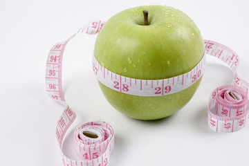 apple and measuring tape on white. Healthy concept