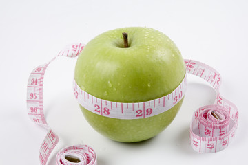 apple and measuring tape on white. Healthy concept