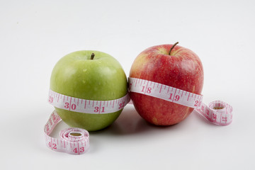 apple and measuring tape on white. Healthy concept