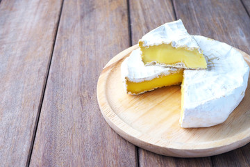 Close up of camembert cheese on a wooden plate.