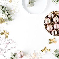 frame made of christmas decoration with christmas glass balls, tinsel, bow, eucalyptus. christmas wallpaper. flat lay, top view