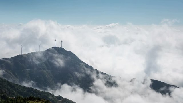 time lapse of sea of clouds at the mountain with wind farm