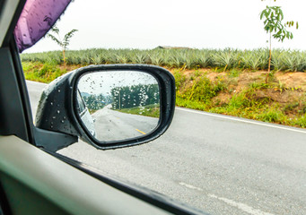 Obraz na płótnie Canvas Landscape in the sideview mirror of a car, on road countryside, natural