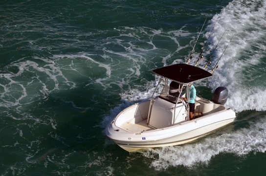 Small outboard powered fishing boat cruising the florida intra-coastal waterway near Miami Beach.