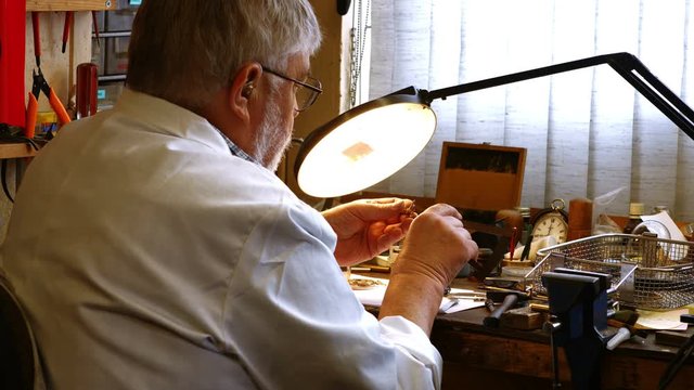 Rear view of horologist repairing a watch