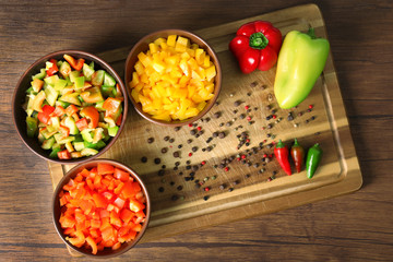 Chopped bell pepper in bowls on cutting board