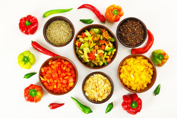 Chopped bell pepper in bowls and chili pepper isolated on white