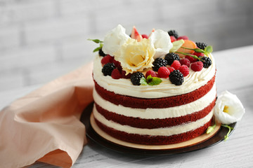 Delicious cake with fruit and berries decoration on white table