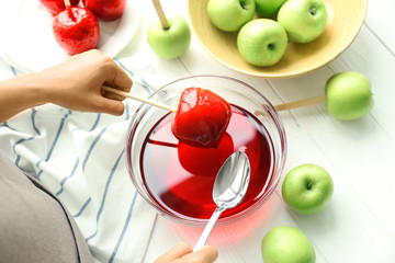 Female hands making caramel apples