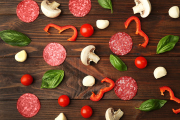 Pizza ingredients on wooden background