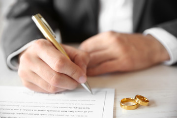 Man signing marriage contract, closeup