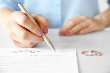 Woman signing marriage contract, closeup