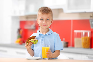Little boy having breakfast in the kitchen