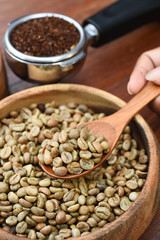 Freshly ground coffee beans in a metal filter and coffee beans with cinnamon for background