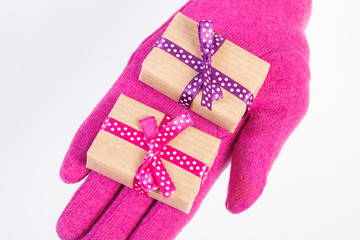 Hand of woman in gloves with gifts for Christmas or other celebration