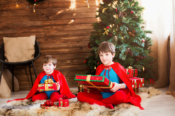  Children in superhero costume and a bunch of Christmas gift boxes. Dreamers.