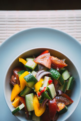 Fresh vegetable salad with olive oil, top view, close-up.