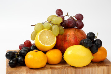 different fruits on a wooden board on a white background