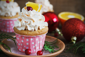 Christmas cupcakes with whipped cream topping and cranberries,orange. festive food dessert.