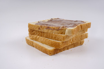 Slice of bread with chocolate hazelnut spread isolated on white