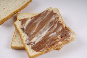 Slice of bread with chocolate hazelnut spread isolated on white