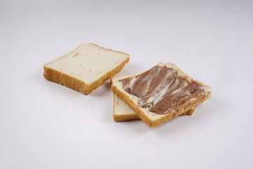 Slice of bread with chocolate hazelnut spread isolated on white