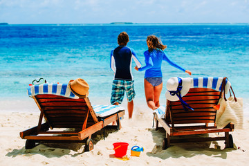 beach vacation - happy couple running to swim at sea