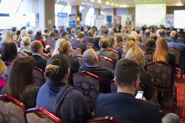Obraz premium Widok osób odwiedzających konferencję biznesową z tyłu.