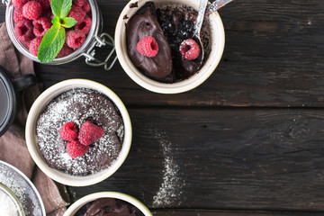 Chocolate cakes with berries on the dark wooden background