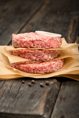Raw ground beef meat cutlets on wooden table