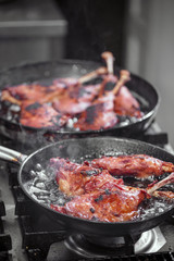 Goose drumstick frying in a pan