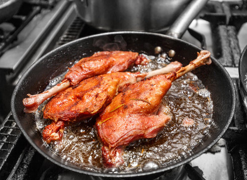 Goose drumstick frying in a pan