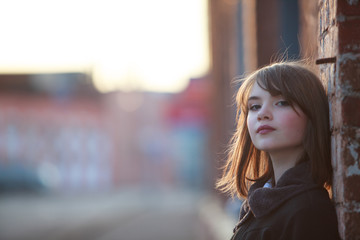 Fototapeta na wymiar Portrait of pretty teenager girl on wall bricks background