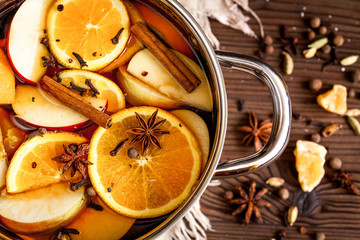 preparation of mulled wine in pot wooden background top view