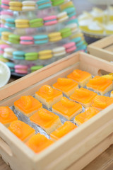 piece of orange cake in wooden box at the party