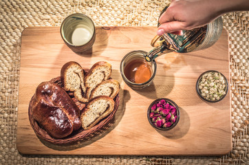Tea drinking ceremony. Flower tea with jasmine and rose buds and delicious home made pastry.