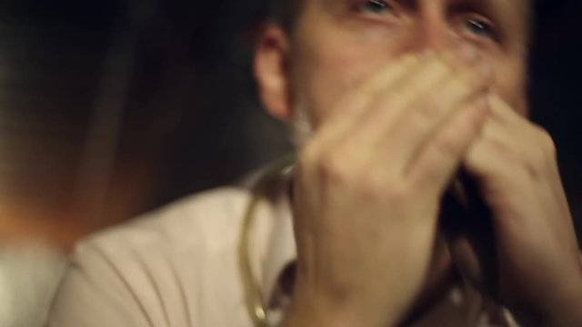 Musician plays the harmonica in the club
