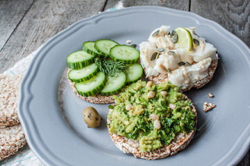 Round buckwheat or rye bread with guacamole, cucumber and fish with tahini. Love for a healthy raw food concept