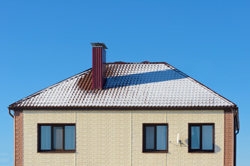 roof cottage with snow against the blue sky