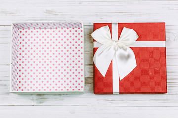 Fototapeta premium Red gift box with ribbon on wooden background