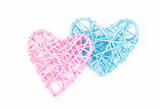 Pink and blue woven Valentines day/Christmas/ Mothers day/ anniversary decorations - hearts isolated, on white background. Wicker heart. Two hearts.  Closeup.