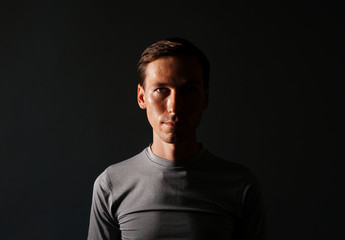 Young man in t-shirt on gray background.