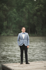 Man, groom posing near forest and lake