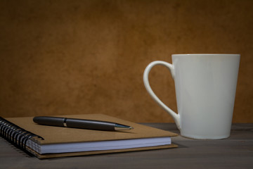 Pen on Notebook with Coffee Cup